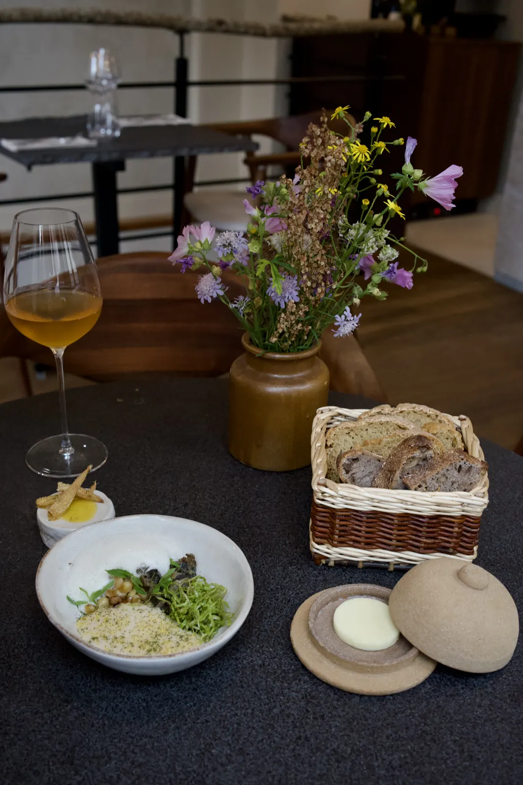Une table dressée : pain, beurre baratté, entrée et vin
